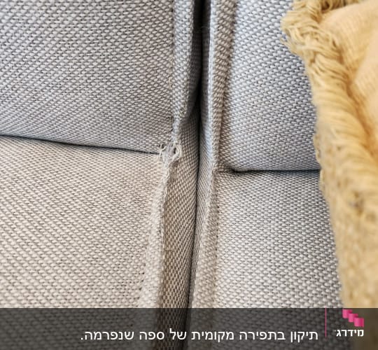 כריות ספה אפורות עם קרע קטן בבד